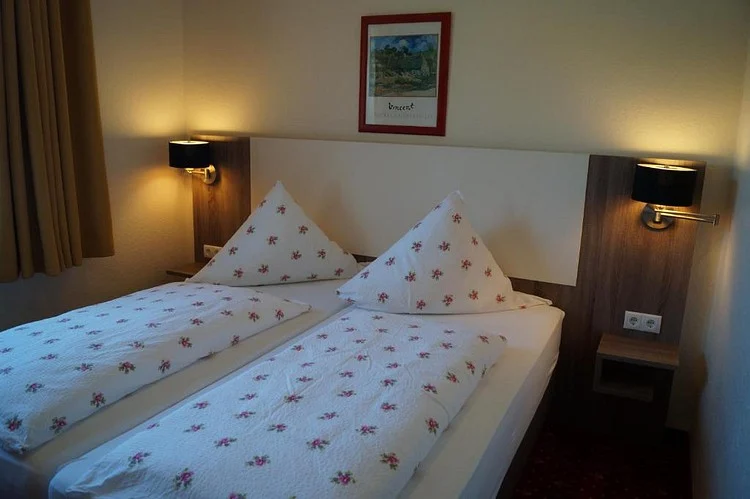 Doppelbett mit Wandleuchten im Hotel Neuses