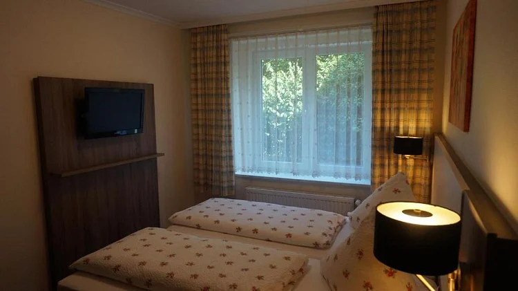 Bett am Fenster mit Fernseher